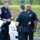 People gather across from the campus of UNC Charlotte after a shooting incident at the school Tuesday, April 30, 2019, in Charlotte, N.C.